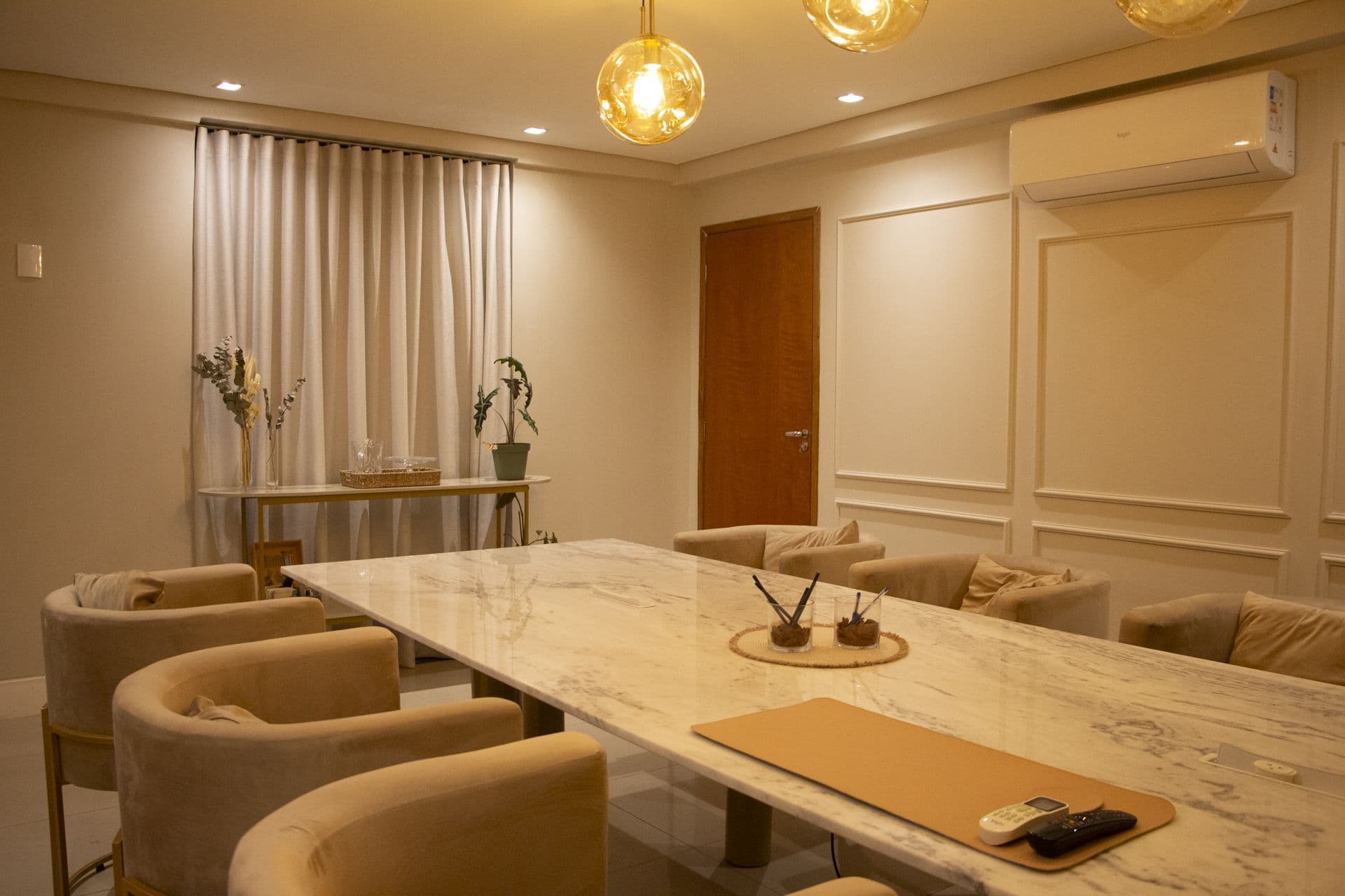 Sala de reunião do Ypê com mesa de mármore, poltronas e ar-condicionado