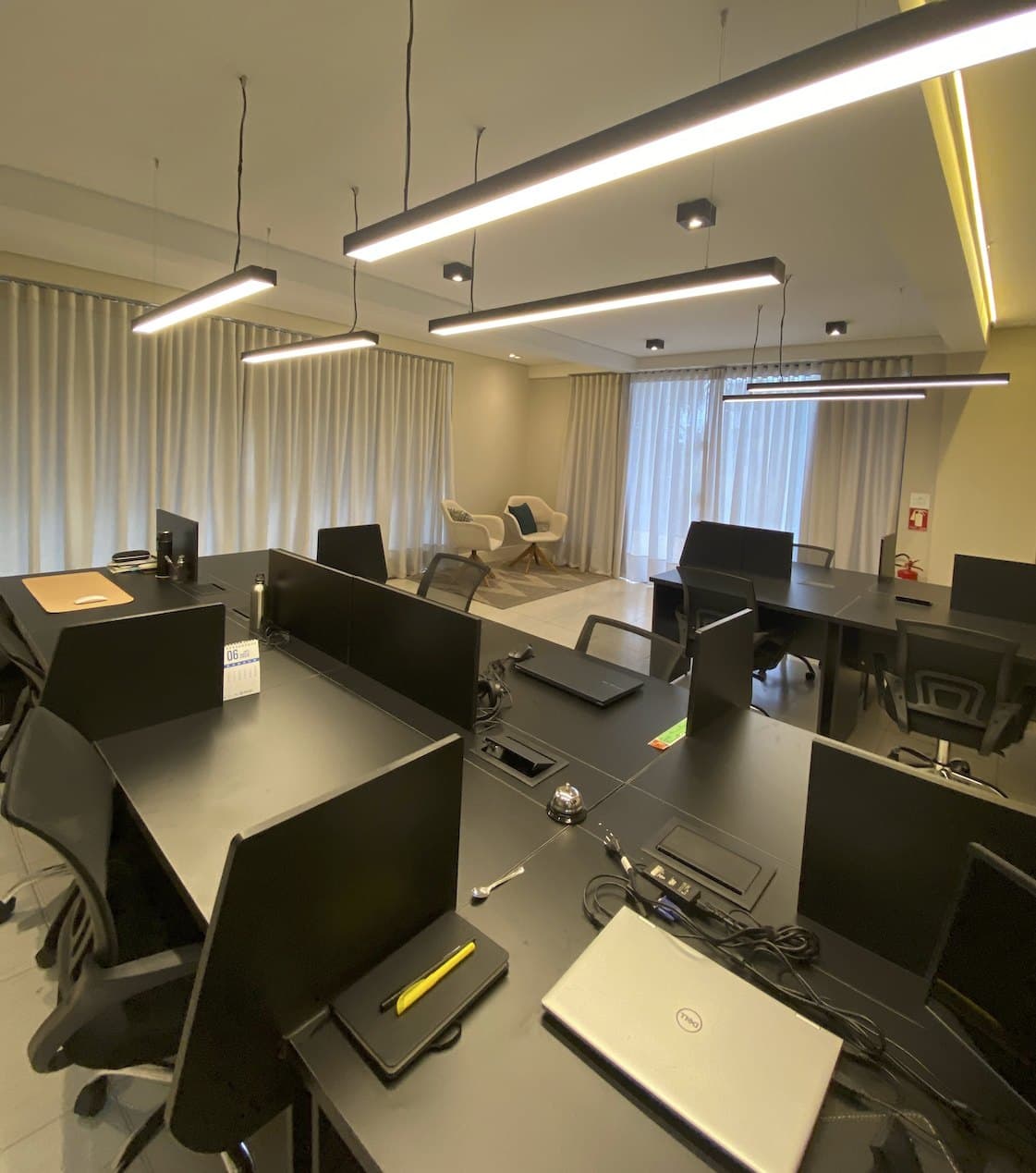 Sala Colaborativa do Ypê Coworking com estações de trabalho e iluminação linear